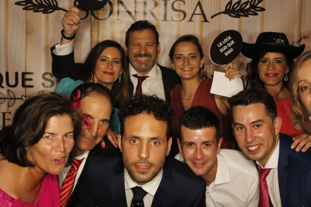 Invitados de boda apretados ante la cámara, riendo