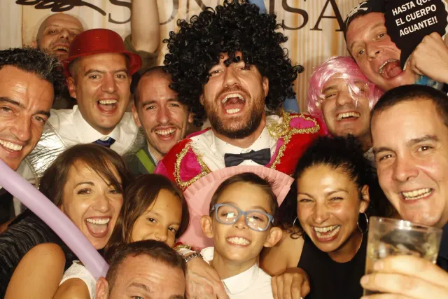 Un grupo de invitados con pelucas riendo a carcajadas